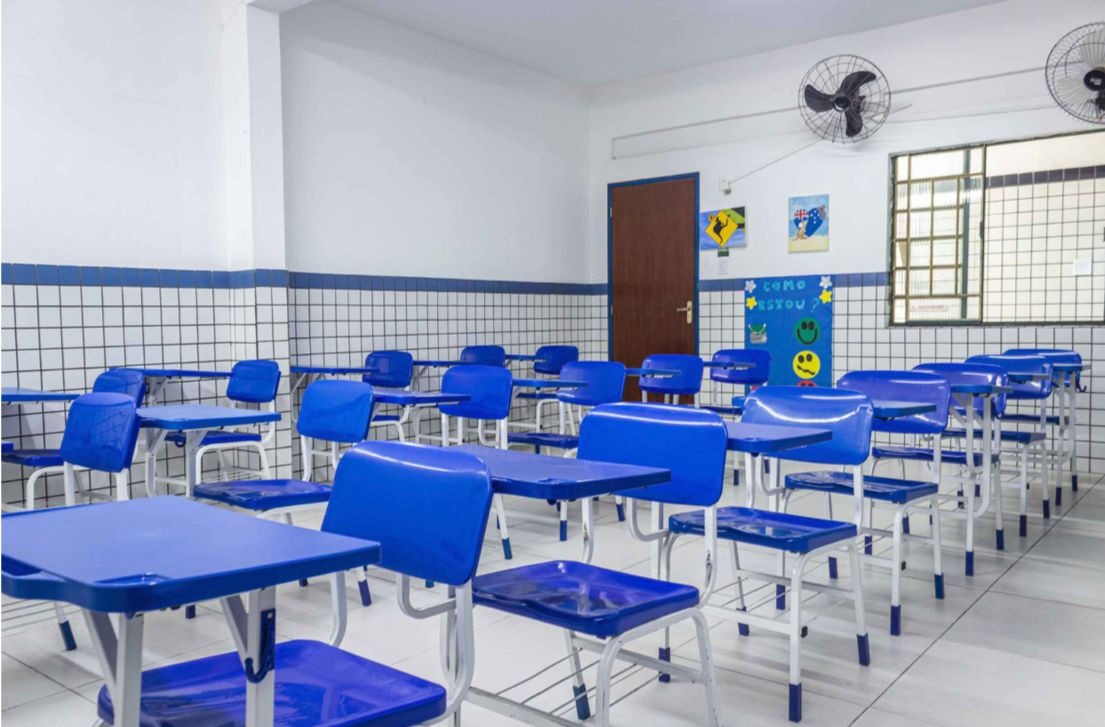 Carteiras escolares azuis em sala de aula organizada